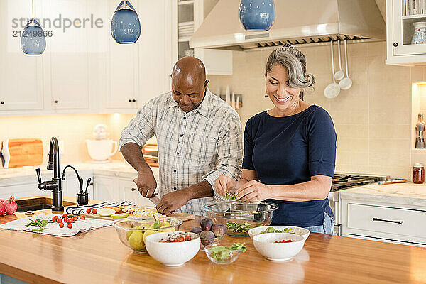 Couple lauhging together while making food