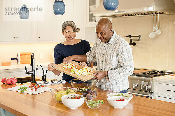 Couple laughing together while cooking