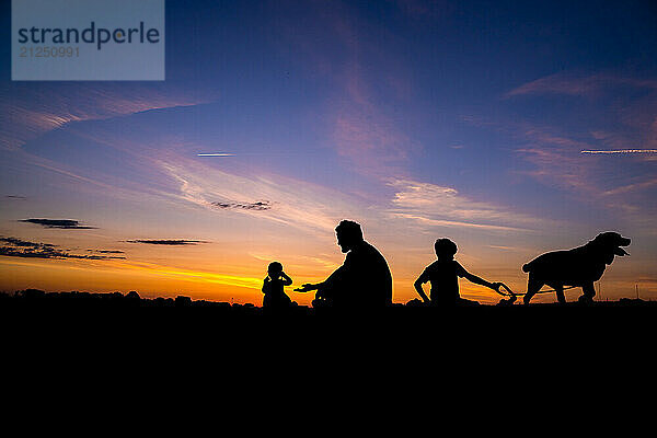 Family With Dog Silhouette During Sunset