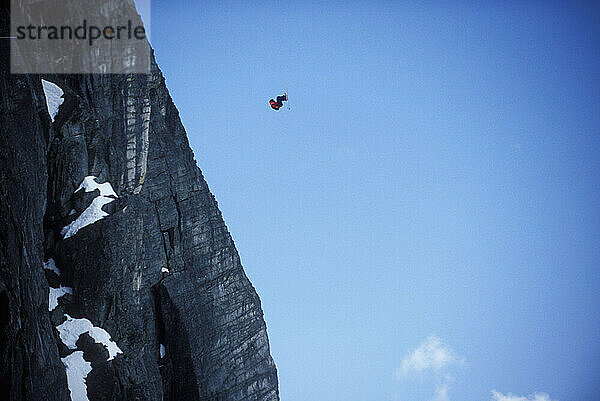 JT Holmes doing a front flip while ski-BASE jumping at Lover's Leap  near Lake Tahoe. Ski-BASEing is a hybrid of extreme skiing and BASE jumping in which one skis of a steep cliff with a parachute.