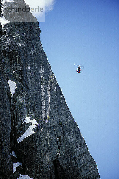 Miles Daisher pulling a front flip while ski-BASE jumping at Lover's Leap  near Lake Tahoe. Ski-BASEing is a hybrid of extreme skiing and BASE jumping in which one skis of a steep cliff with a parachute. There is little room for error.