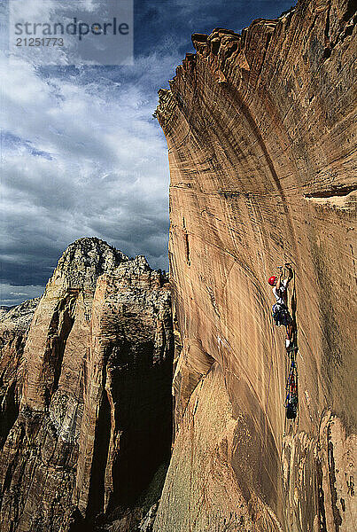 Big Wall rock climber Chris McNamara on the final headwall of a new route on the Right Twin formation in Zion N.P. Mountain of the Sun is in the background. Chris founded the American Safe Climbing Association and SuperTopo.com