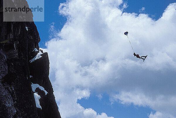 Mark Ridley pulling a back flip while Snowboard-BASE jumping at Lover's Leap  near Lake Tahoe. Board-BASEing is a hybrid of extreme snowboarding and BASE jumping in which one rides off a steep cliff with a parachute.