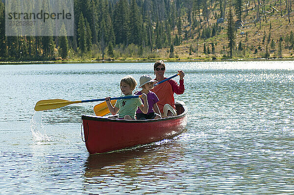 A family paddles a canoe in Grand Teton National Park  Jackson Hole  Wyoming.