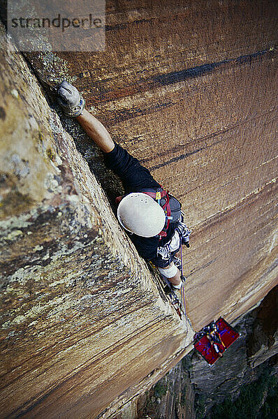 Climber placing a piton while climbing in Zion National Park  Utah.