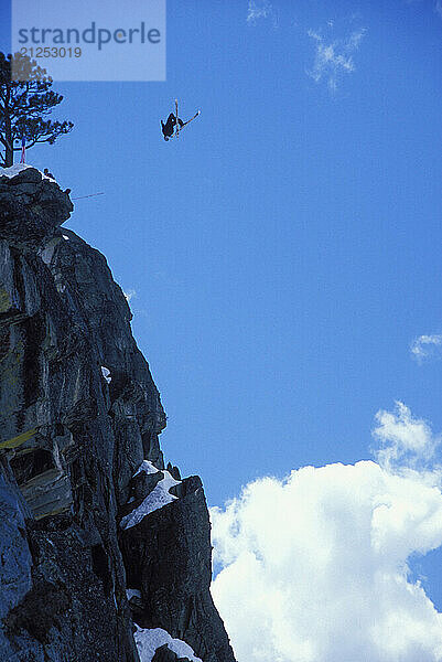 Eric Roner pulling a back flip while ski-BASE jumping at Lover's Leap  near Lake Tahoe. Ski-BASEing is a hybrid of extreme skiing and BASE jumping in which one skis of a steep cliff with a parachute. There is little room for error.