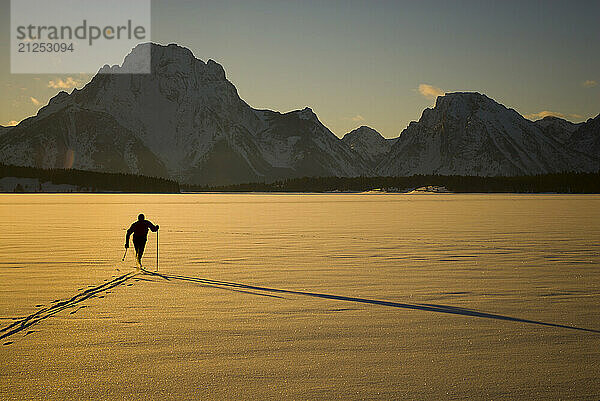 A young man nordic skis on Jackson Lake in Grand Teton National Park  Jackson Hole  Wyoming.