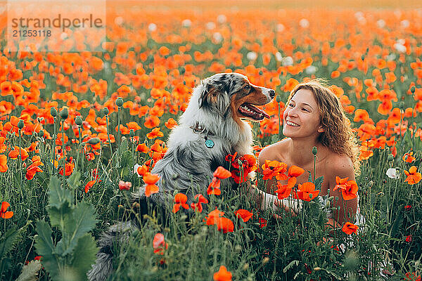 young woman shares playful moments with her australian shepherd dog