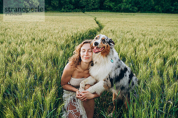 Young woman enjoying a sunny day with her australian shepherd