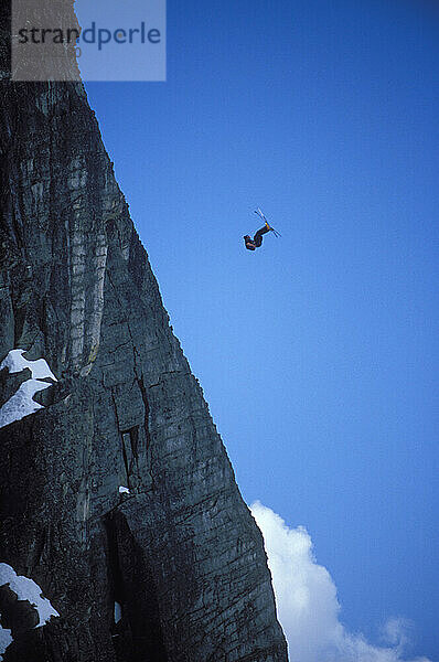 Ski-BASE jumper doing a front flip at Lover's Leap  near Lake Tahoe California. Ski-BASEing is a hybrid of extreme skiing and BASE jumping in which one skis of a steep cliff with a parachute.