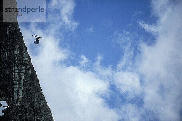 Karina Hollekim doing a front flip while ski-BASE jumping at Lover's Leap  near Lake Tahoe  California. Ski-BASEing is a hybrid of extreme skiing and BASE jumping in which one skis off a steep cliff with a parachute. Karina  a professional athlete from Norway and is currently the only know female ski BASE jumper.