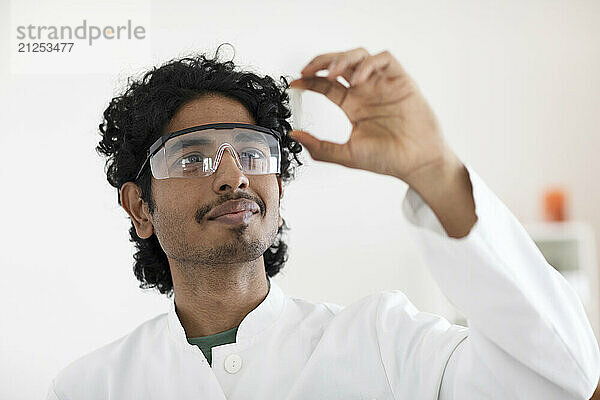 young scientist male working in a labor with a sample in the hand