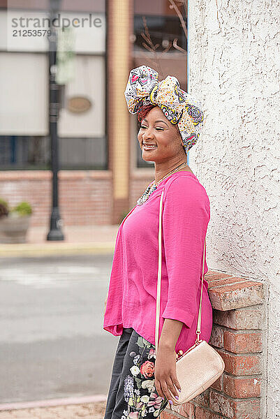 Woman laughing outside wearing bright clothing