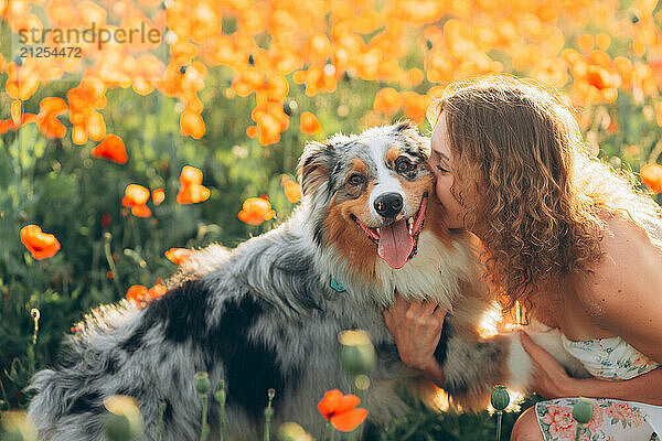 vibrant poppy field a young woman shares with her dog