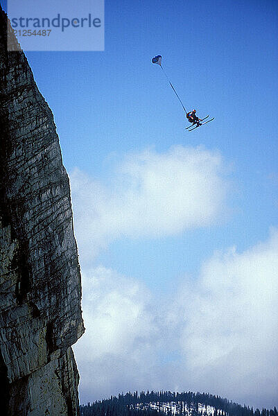 Miles Daisher ski-BASE jumping at Lover's Leap  near Lake Tahoe. Ski-BASEing is a hybrid of extreme skiing and BASE jumping in which one skis of a steep cliff with a parachute. There is little room for error.