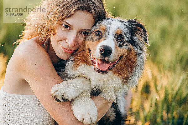 Young woman and Australian Shepherd dog  close-up portrait