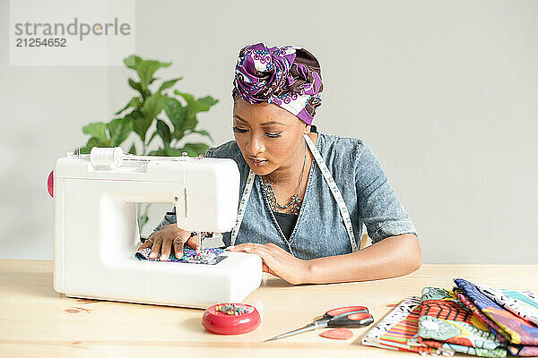 Woman sowing on a sowing machine with fabric