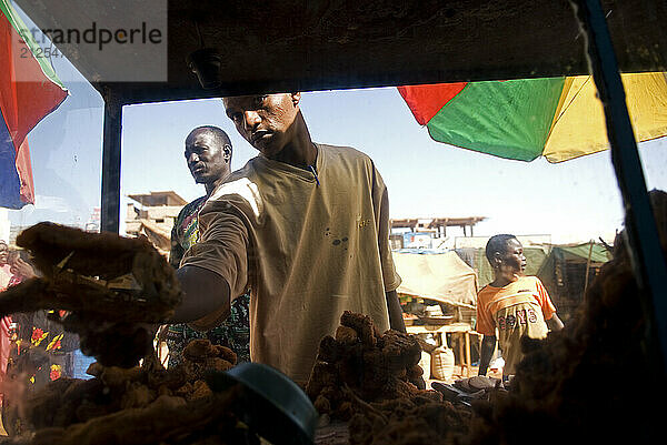 Seller passing fried fish to a customer  Omdurman  Sudan