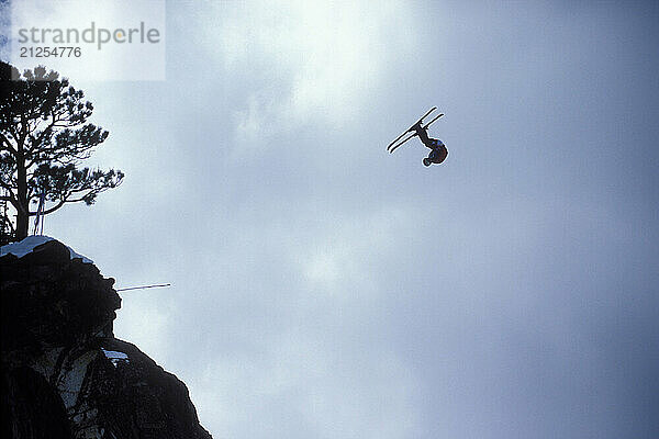 Miles Daisher pulling a front flip while ski-BASE jumping at Lover's Leap  near Lake Tahoe. Ski-BASEing is a hybrid of extreme skiing and BASE jumping in which one skis of a steep cliff with a parachute. There is little room for error.