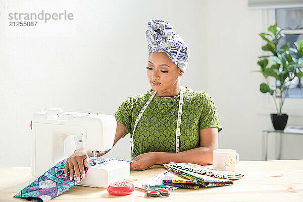 Woman using sowing machine on fabric