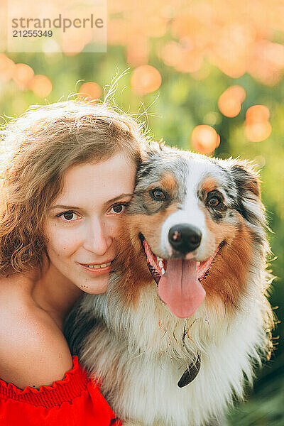 Portrait of a young woman and her Australian Shepherd dog