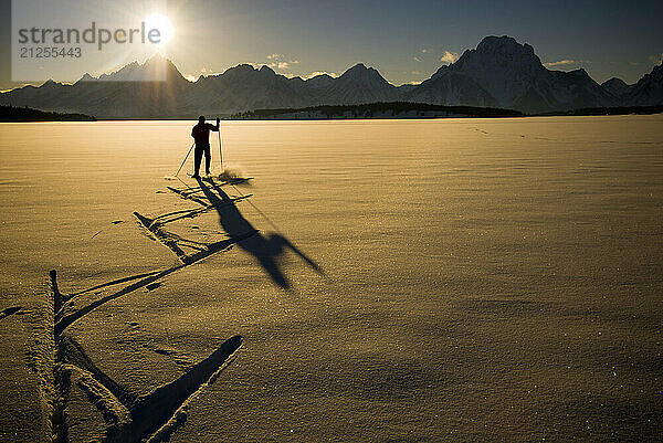 A young man skate skis on Jackson Lake in Grand Teton National Park  Jackson Hole  Wyoming.