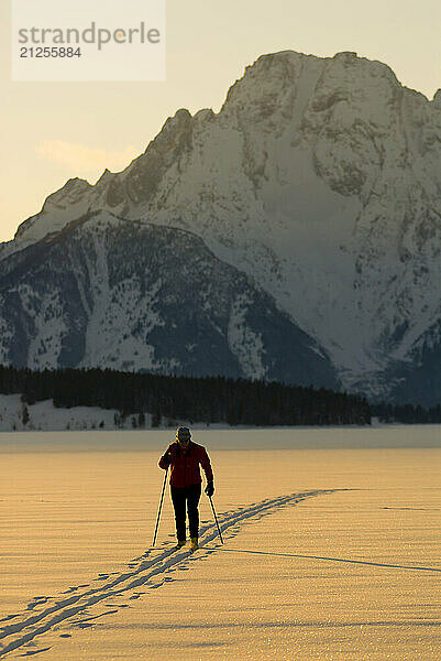 A young woman nordic skis on Jackson Lake in Grand Teton National Park in Jackson Hole  Wyoming.