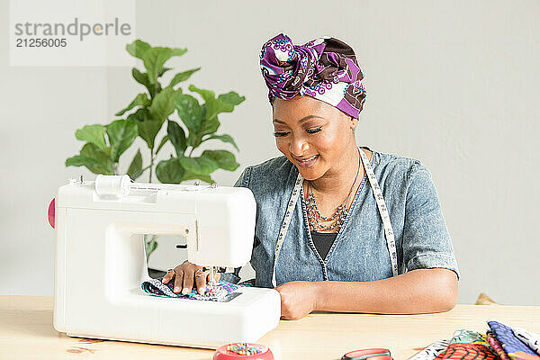 Nigerian woman sowing head wraps