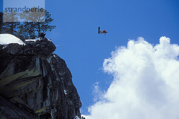 Mark Ridley pulling a back flip while Snowboard-BASE jumping at Lover's Leap  near Lake Tahoe. Board-BASEing is a hybrid of extreme snowboarding and BASE jumping in which one rides off a steep cliff with a parachute.