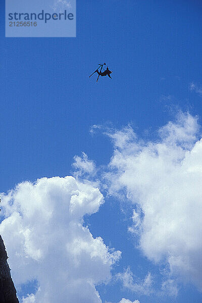 Eric Roner pulling a back flip while ski-BASE jumping at Lover's Leap  near Lake Tahoe. Ski-BASEing is a hybrid of extreme skiing and BASE jumping in which one skis of a steep cliff with a parachute.