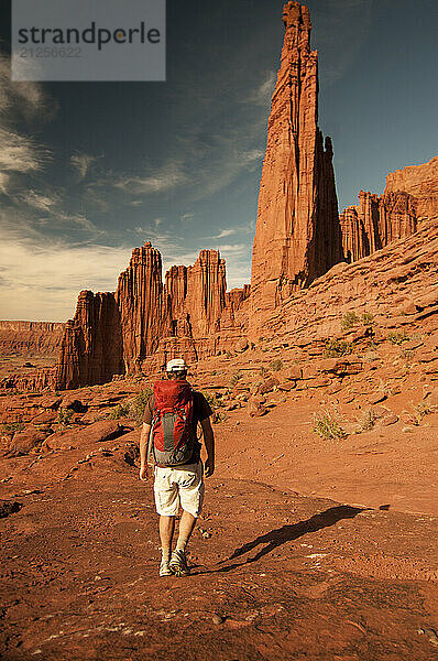 A young man hikes the Fisher Towers trail in Castle Valley  Utah.