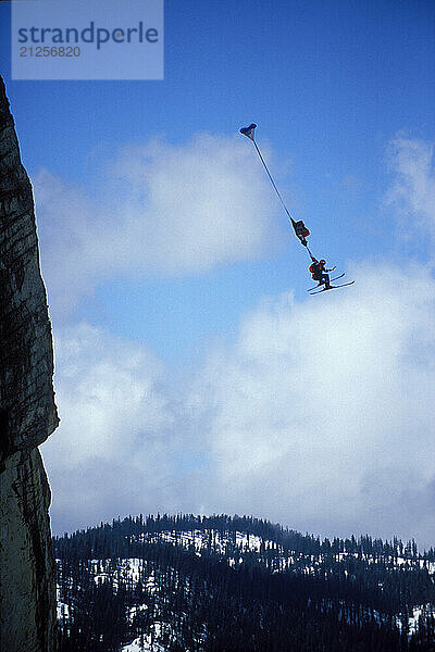 Miles Daisher's parachute deploys while skiBASE jumping at Lover's Leap  near Lake Tahoe. SkiBASEing is a hybrid of extreme skiing and BASE jumping in which one skis of a steep cliff with a parachute. There is little room for error.