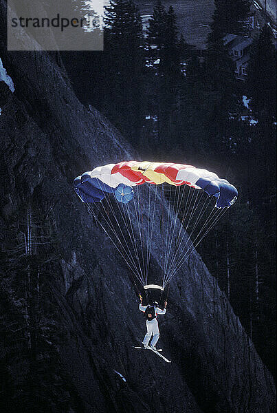 Jesse Hall doing a front flip while ski-BASE jumping at Lover's Leap  near Lake Tahoe. Ski-BASEing is a hybrid of extreme skiing and BASE jumping in which one skis off a steep cliff with a parachute.