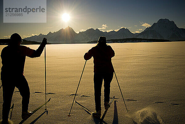 A young couple enjoys nordic skate skiing on Jackson Lake in Grand Teton National Park  Jackson Hole  Wyoming.