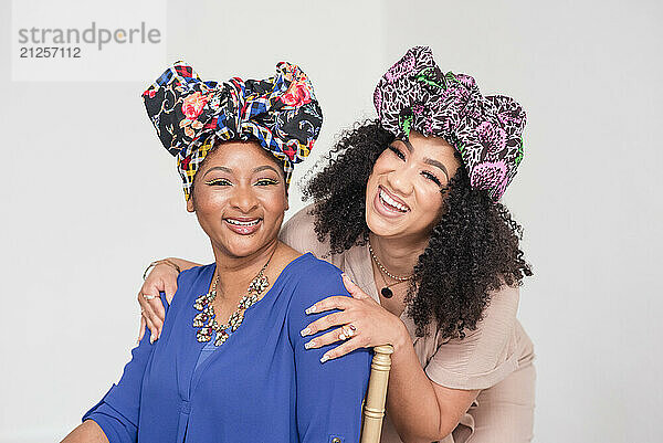 Lauhing women looking at the camera while wearing headwraps