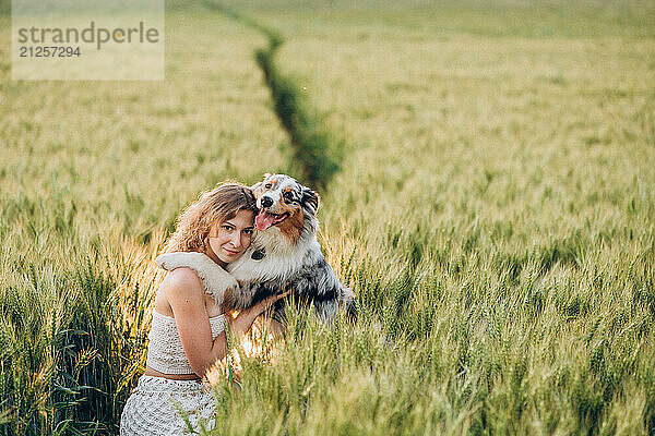 Young woman enjoying with her australian shepherd dog