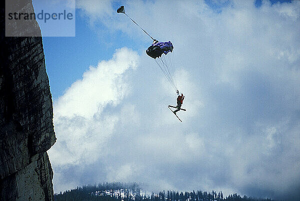 JT Holmes ski-BASE jumping at Lover's Leap  near Lake Tahoe  California. Ski-BASEing is a hybrid of extreme skiing and BASE jumping in which one skis of a steep cliff with a parachute.