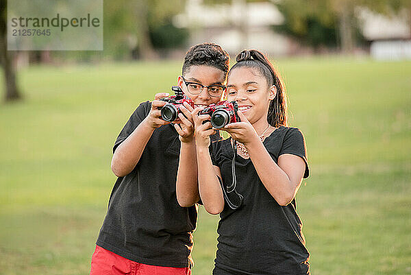 Twin brother and sister showing each other their photos