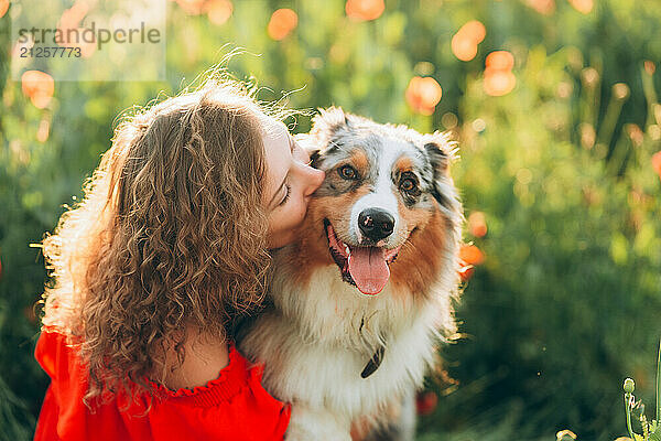 Portrait of a woman and Australian Shepherd dog in summer