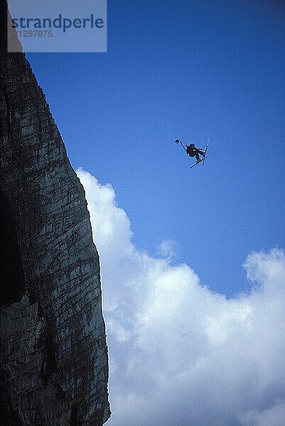 Ski-BASE jumper doing a front flip at Lover's Leap  near Lake Tahoe California. Ski-BASEing is a hybrid of extreme skiing and BASE jumping in which one skis of a steep cliff with a parachute.