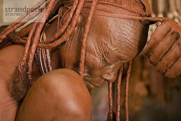 A Himba women will spend many hours on their beauty  appearance and grooming everyday. They cream their entire body with a mixture of rancid butterfat and ochre that has been scented with the aromatic resin of the Omuzumba shrub. The cream lends the body and intense reddish glow that protects them from the sun and harsh desert environment of the Namib desert in Namibia.