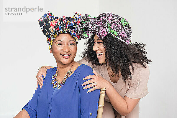 Two women with headwraps laughing together