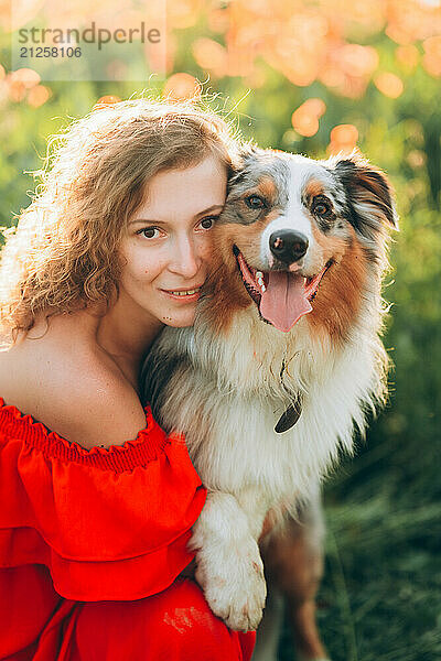 woman enjoying a sunny day with her australian shepherd dog