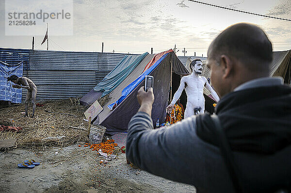 A passer-by taking pictures of Sadhus during Kumbh Mela  Allahabad  Uttar Pradesh  India.