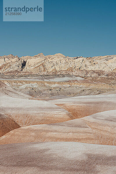 Colorful Desert Landscape Of Bentonite Clay With A Mountain Backdrop