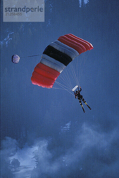 John Garrett landing his parachute after ski-BASE jumping at Lover's Leap  near Lake Tahoe  California. Ski-BASEing is a hybrid of extreme skiing and BASE jumping in which one skis of a steep cliff with a parachute. There is little room for error.