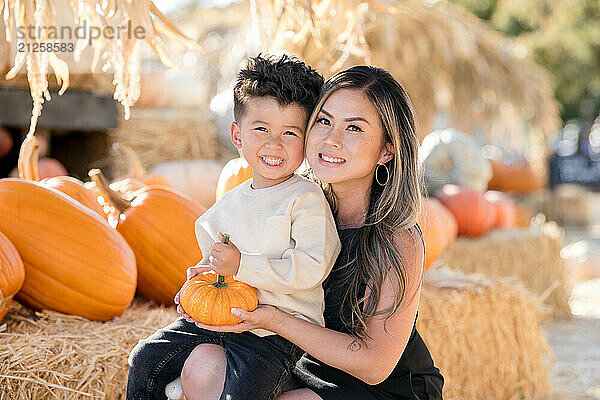 Little boy sitting on mothers lap and both are smiling