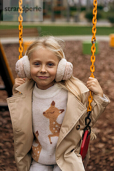 A little girl swings on a swing in an autumn park