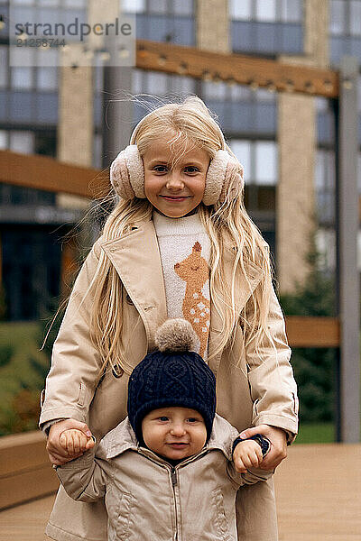 Sister plays with her younger little brother in the park