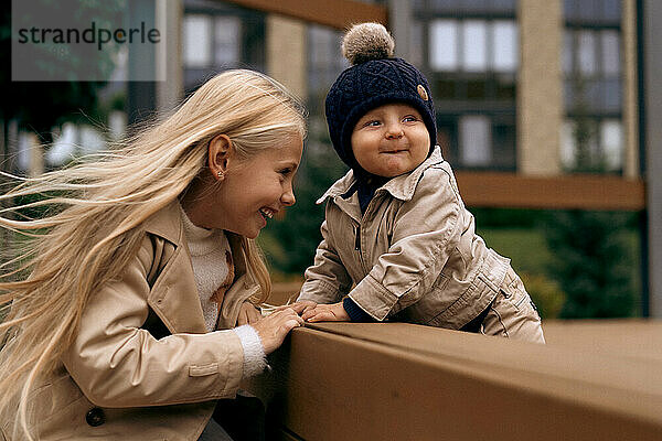 Sister plays with her younger little brother in the park